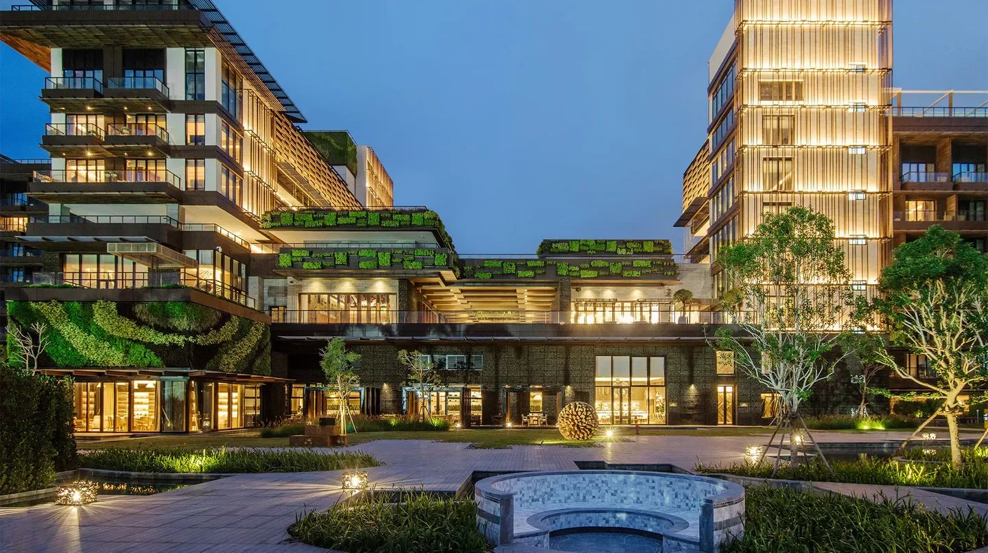 Night view of 1 Hotel Haitang Bay, Sanya, with illuminated architecture and landscaping.