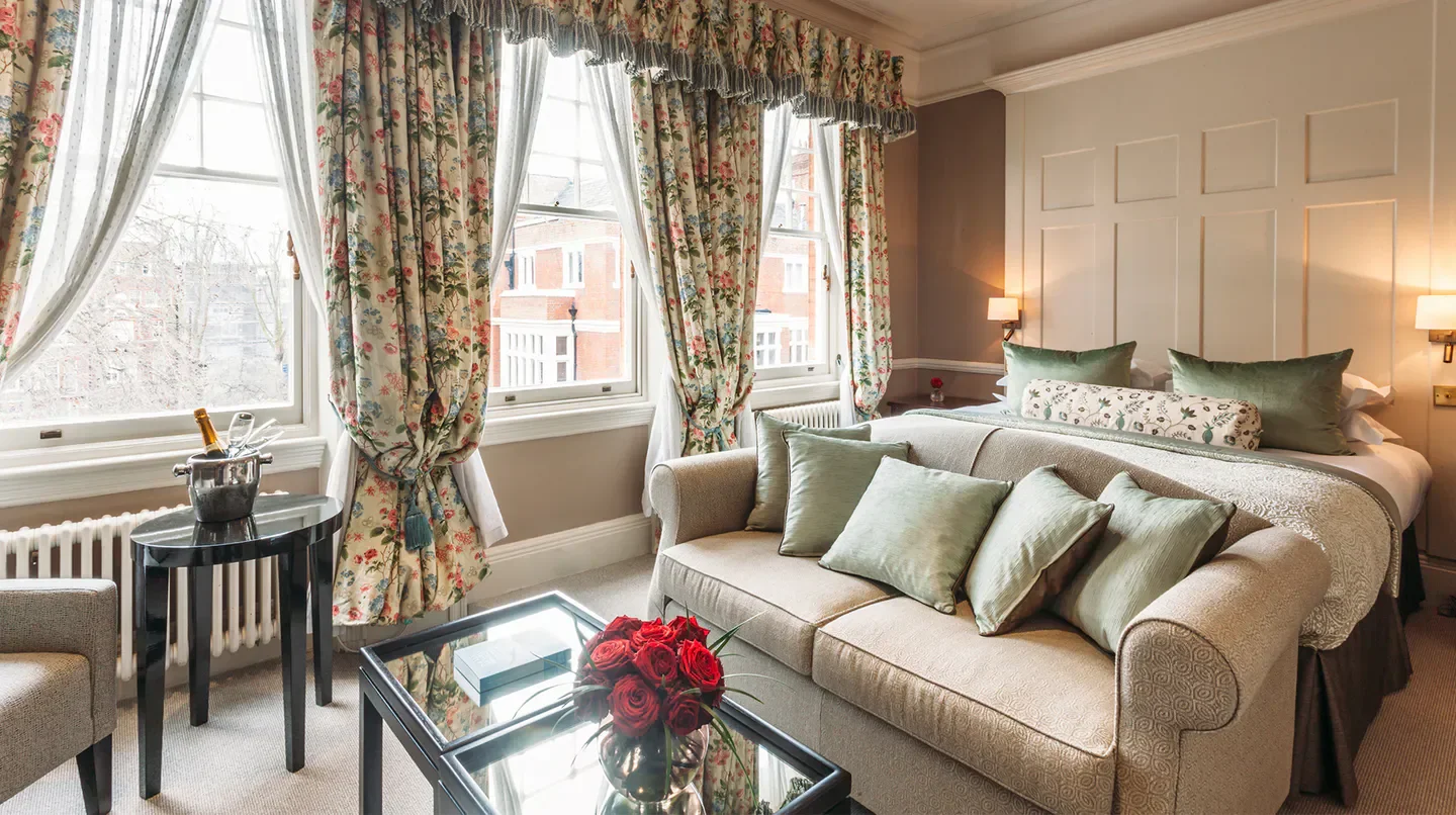 Elegant hotel room at 11 Cadogan Gardens, London, with floral curtains and sofa.