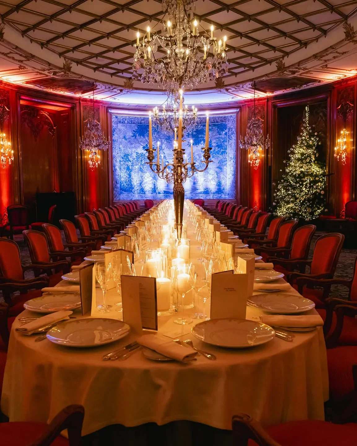 Elegant dining at 114 Faubourg in Paris, with a long candlelit table and Christmas tree.