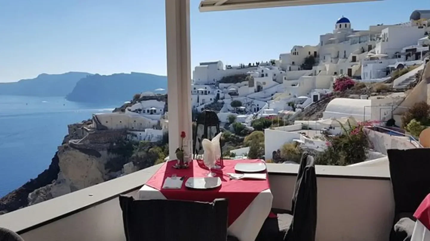 Restaurant seating at 1800 Floga in Santorini overlooking the caldera and village.