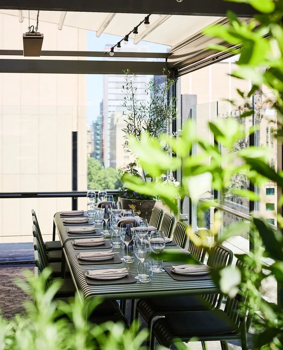 Outdoor dining at 2KW Bar & Restaurant in Adelaide, featuring city views and elegant table settings.