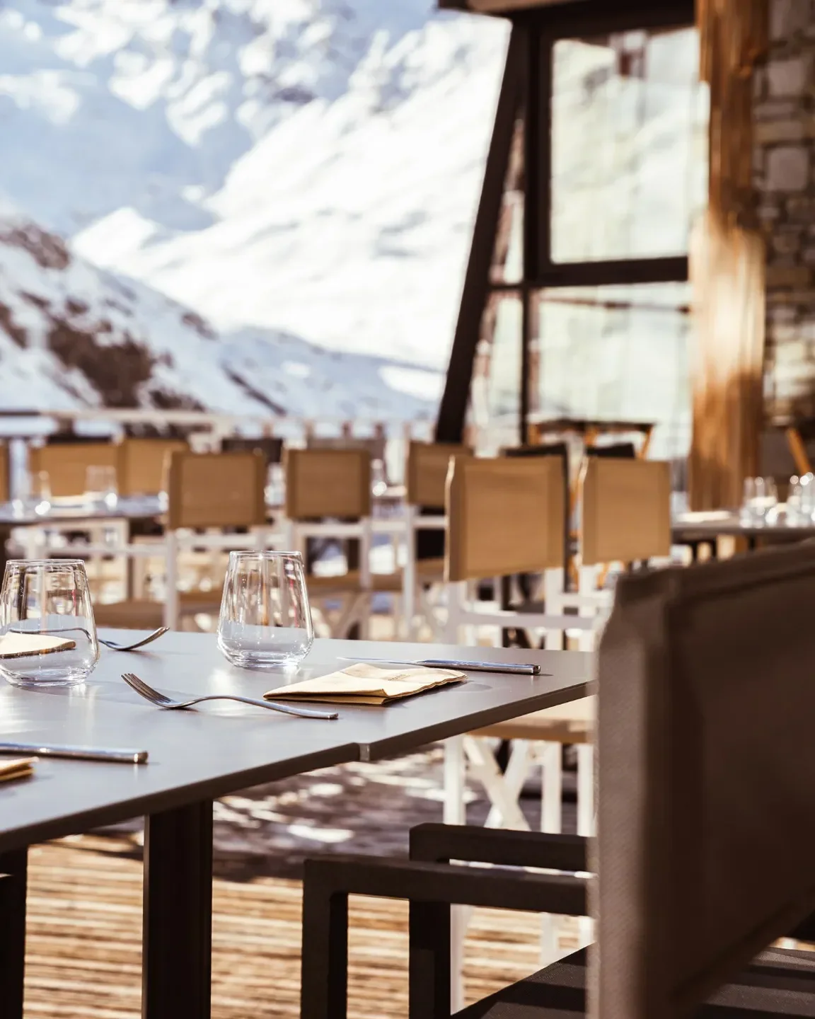 Dining table at 2Mille3 restaurant in Val Thorens with a view of snow-capped mountains.