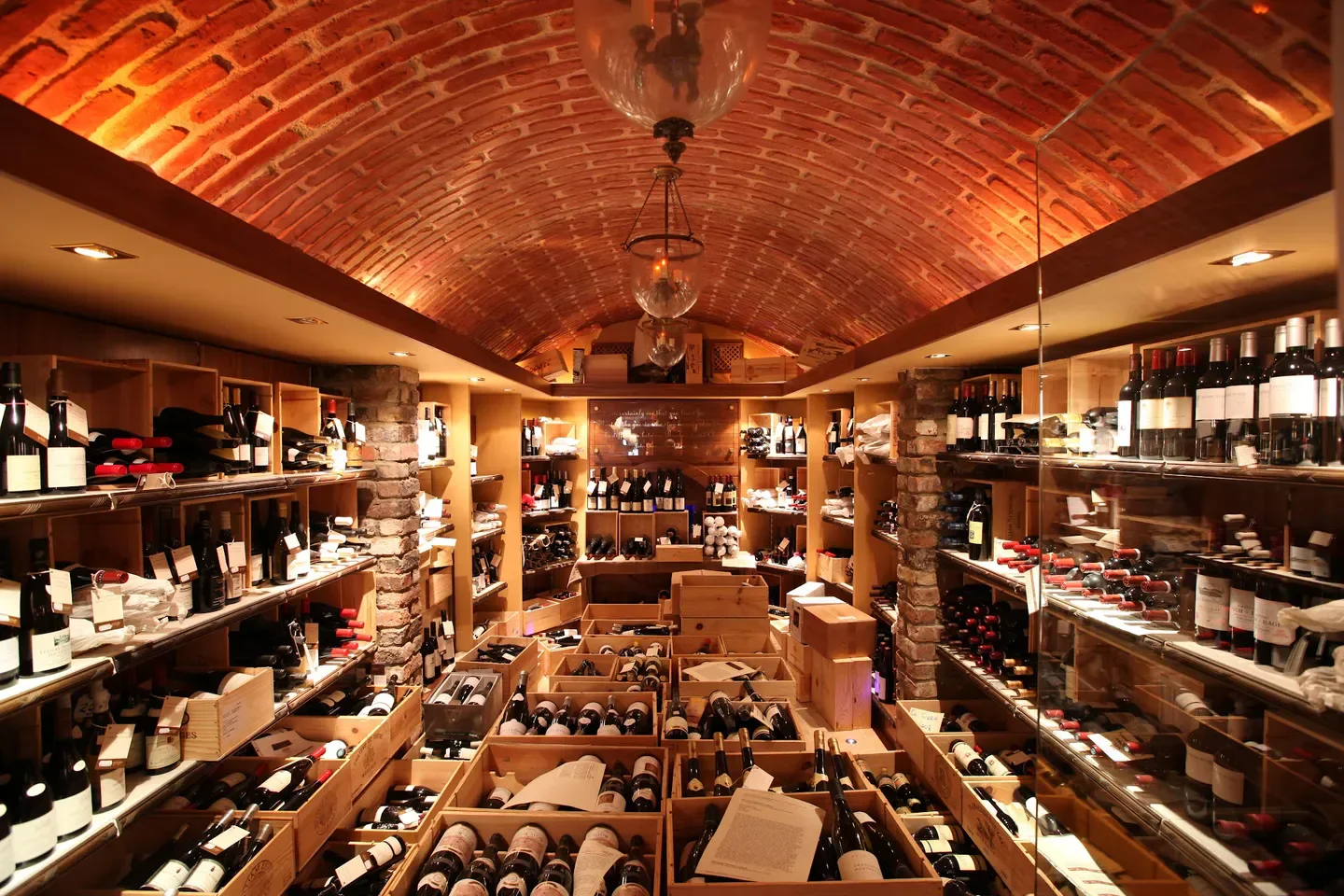Wine cellar interior at 64 Wine in Dublin, displaying bottles and brickwork ceiling.