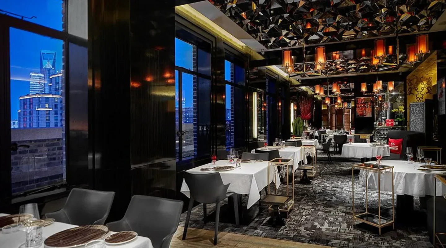 Elegant interior of 8 ½ Otto e Mezzo Bombana restaurant in Shanghai with city views.