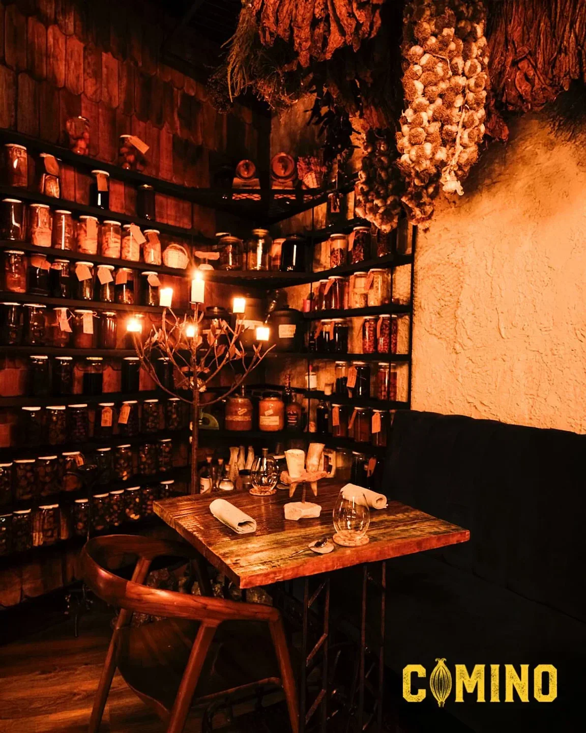 Cozy dining area at 99 Restaurante in Santiago, with jars and candles.