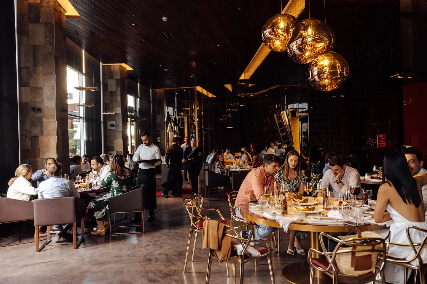 Dining scene at 99 Sushi Bar, Abu Dhabi, with elegant interior and attentive service.