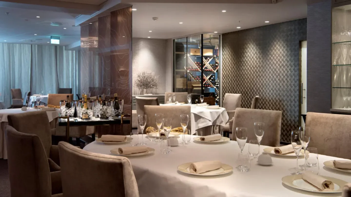 Elegant dining room interior at À L'aise restaurant in Oslo, featuring tables set for dinner