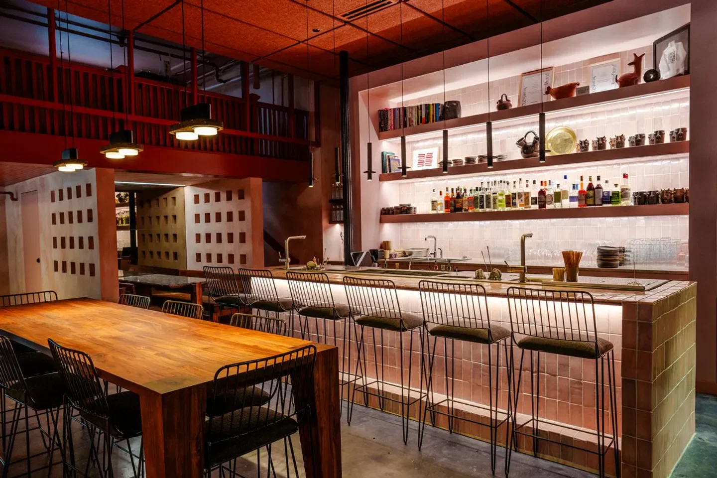 Interior of Acamaya restaurant in New Orleans with bar seating and overhead lighting