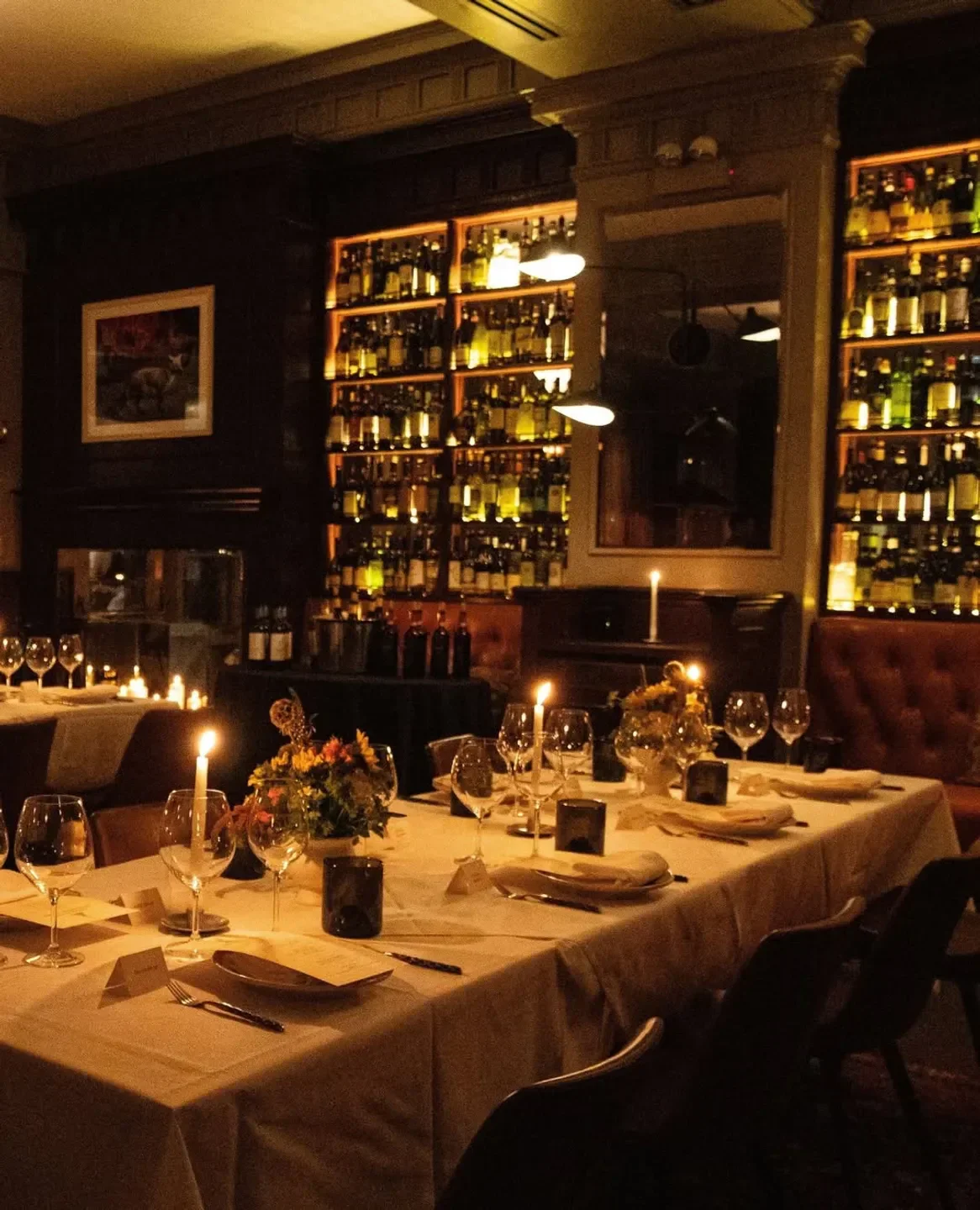 Cozy dining at Acanto Chicago, featuring candlelit tables and a wine display.