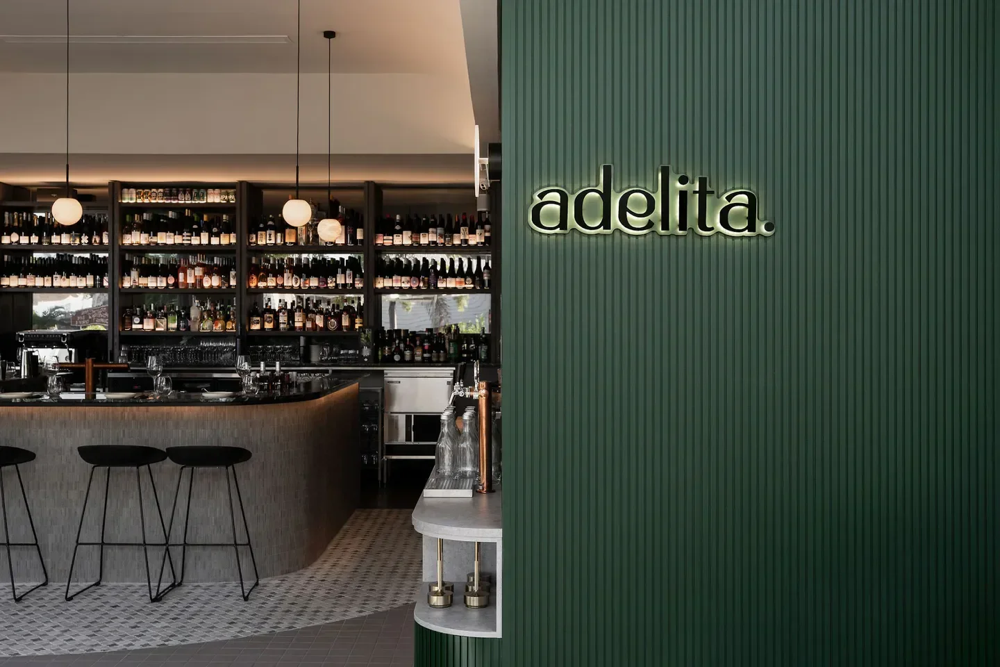Interior of Adelita Wine Bar in Brisbane, featuring stylish bar and bottle display.