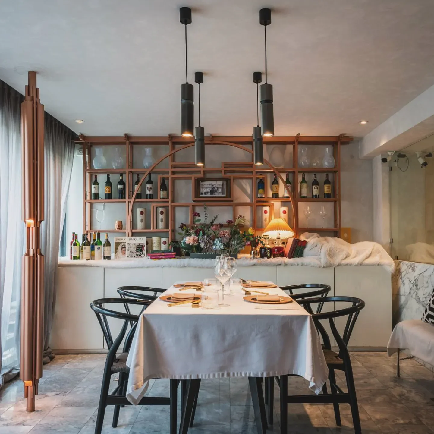 Elegant dining room interior at ADHOC Bangkok restaurant, with prepared table and stylish decor.