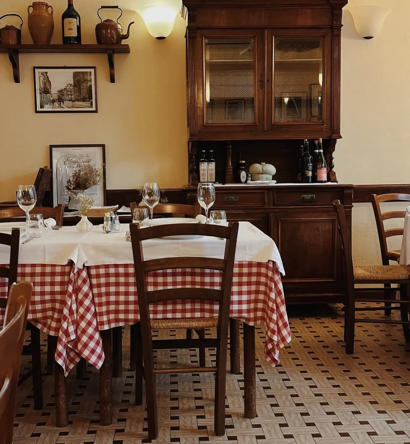 Cozy dining room at Ai Due Platani in Parma, featuring a checkered tablecloth and wooden furniture.