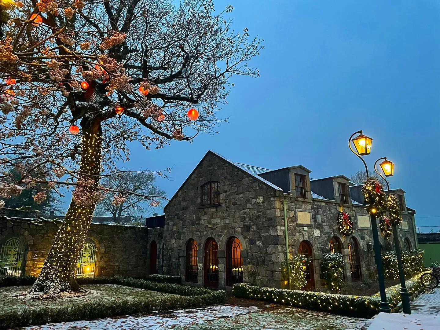 Winter exterior of Aimsir in Dublin, with festive lights and snow-covered surroundings.