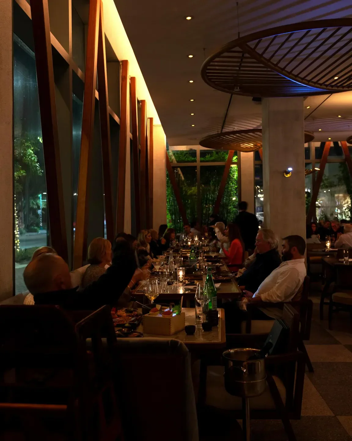 Dining room at Akira Back Palm Beach with people at a long table, elegant setting