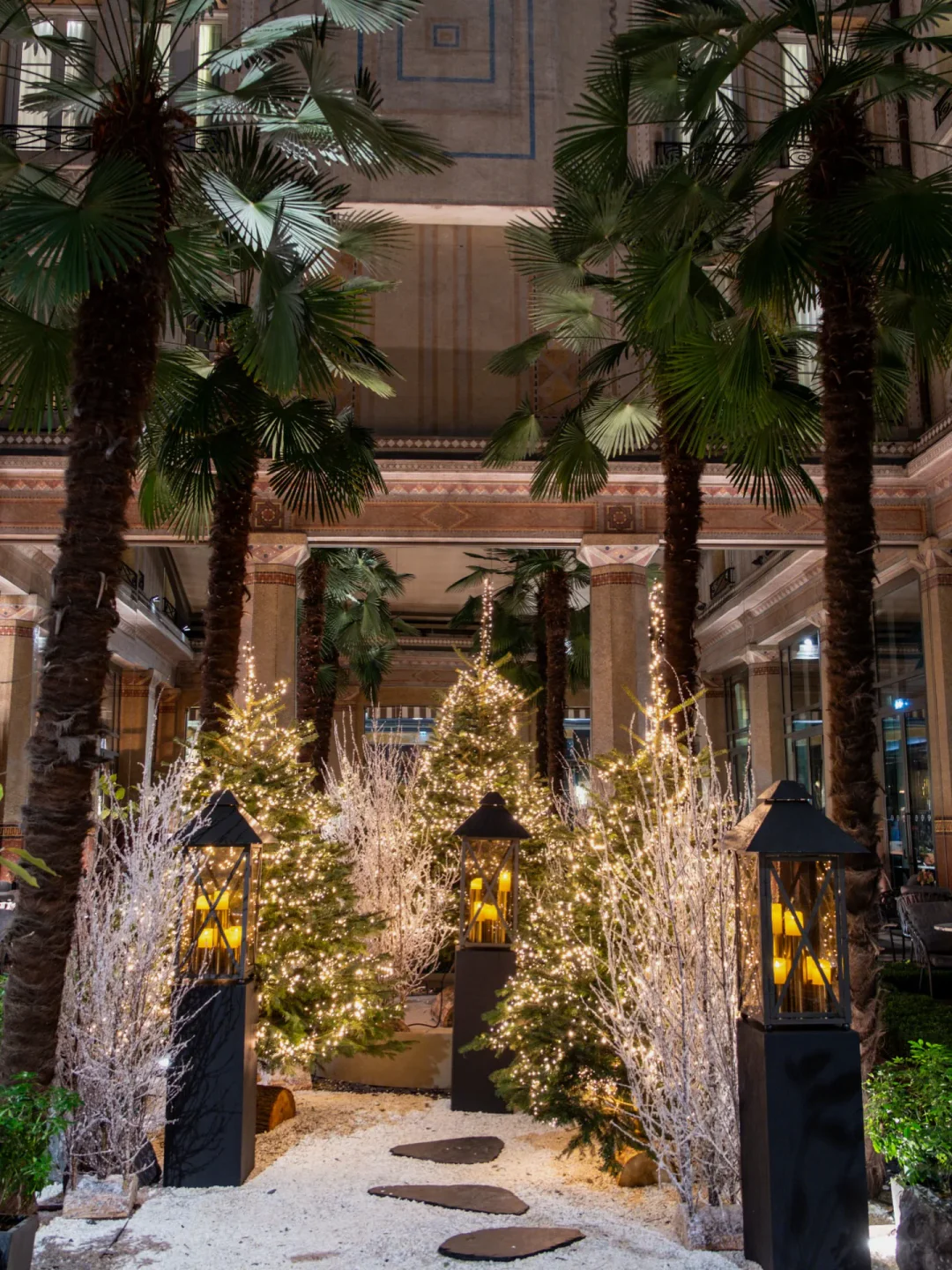 Festive interior at Akira Back Paris featuring palm trees, fairy lights, and holiday decor within the restaurant.