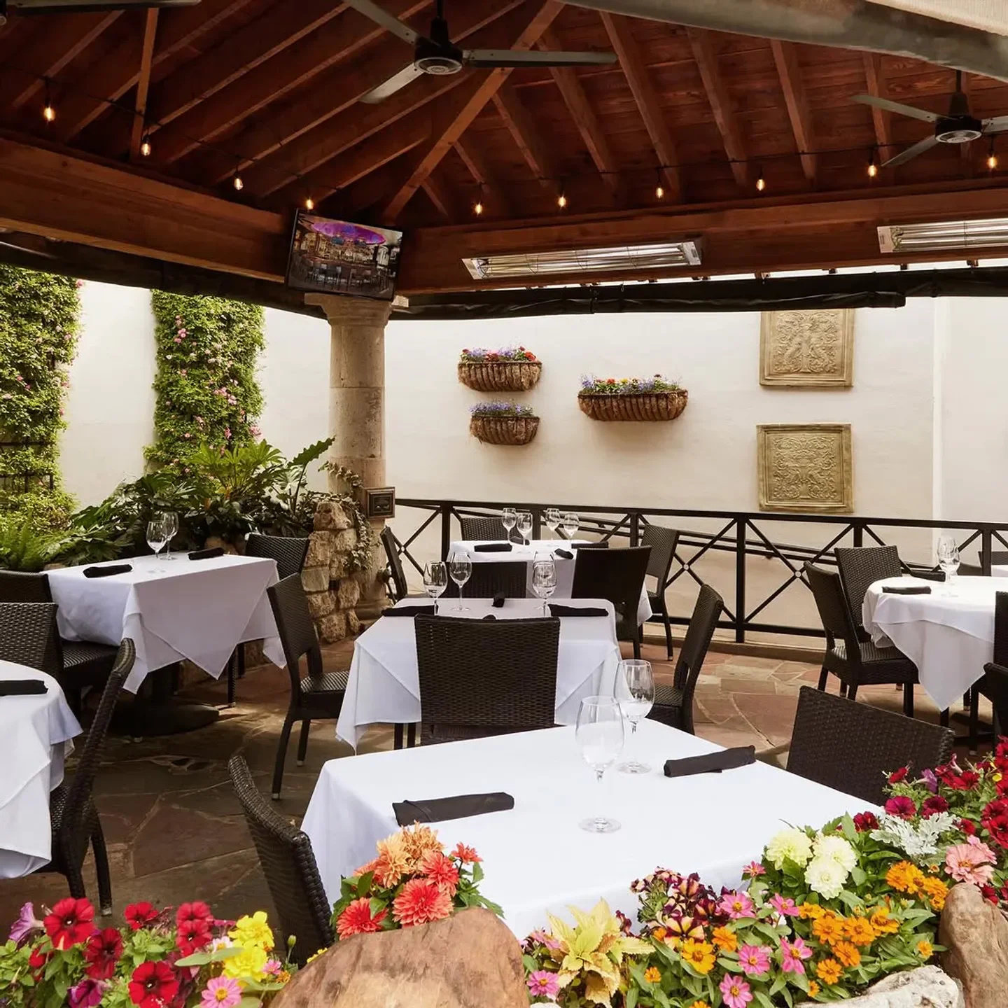 Outdoor patio at Al Biernat's in Dallas, with flower beds and tables set for dining.