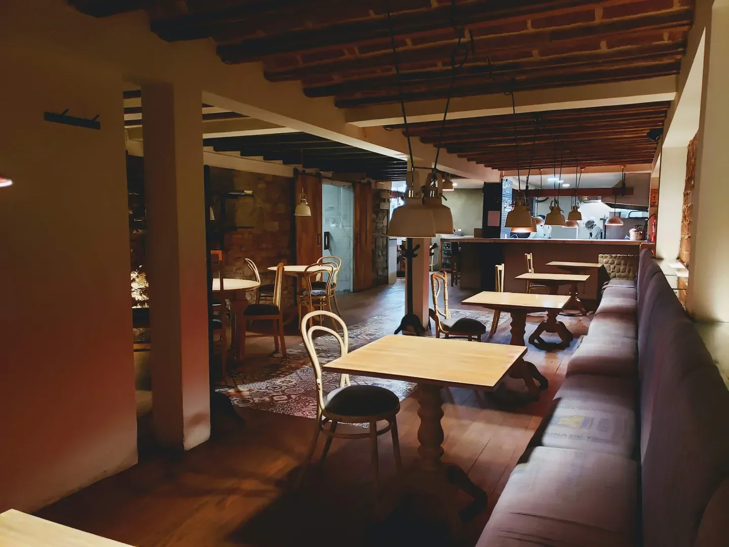 Cozy interior of Ali Pacha restaurant in La Paz with tables and seating.