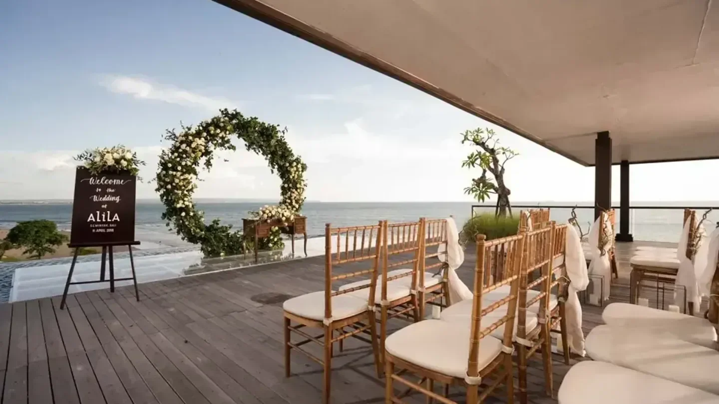 Wedding setup at Alia Seminyak Beach Bar in Bali, with ocean views and floral arch.