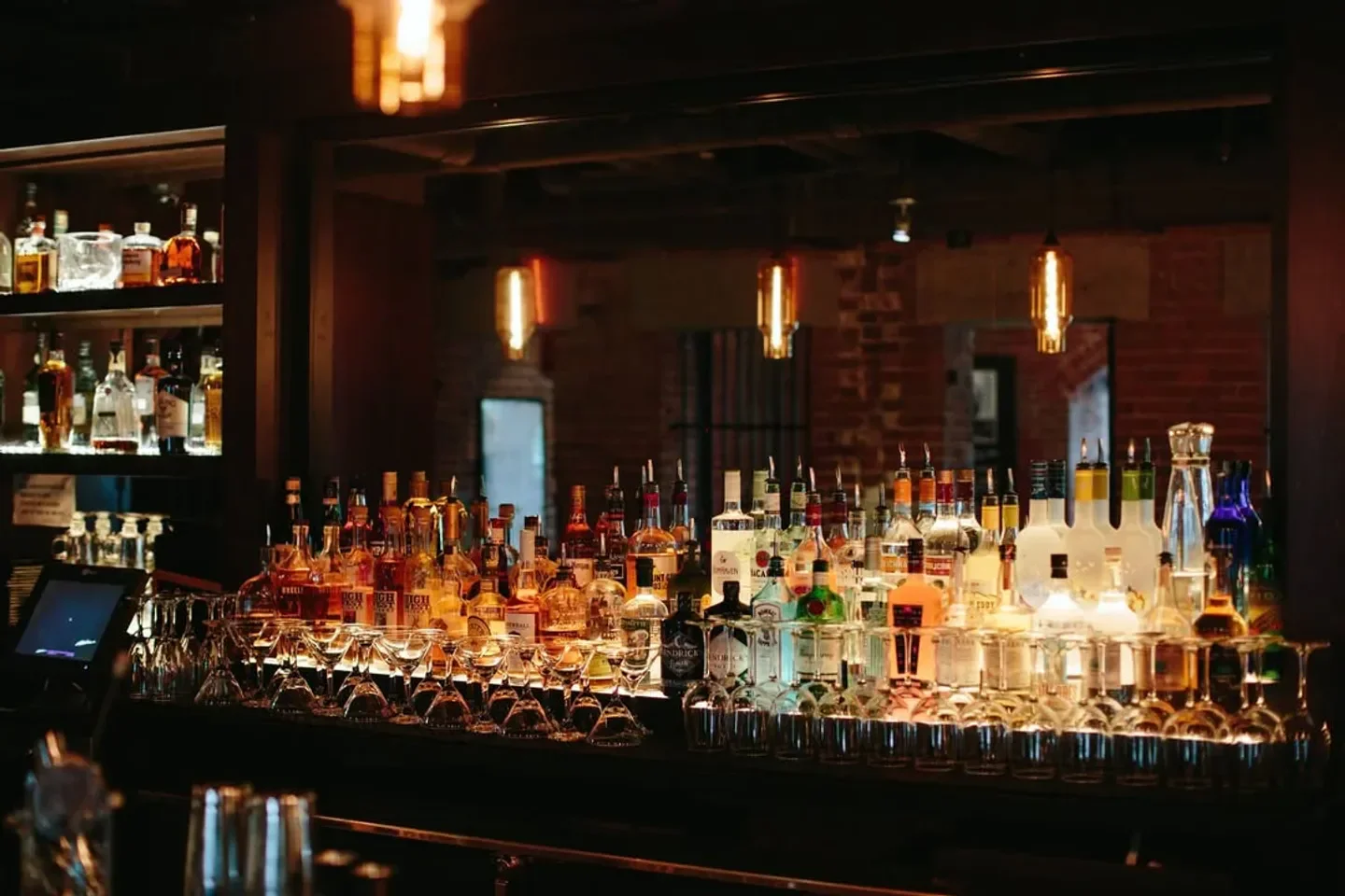 Well-stocked bar at Alibi nightclub in Boston, with bottles and glasses.