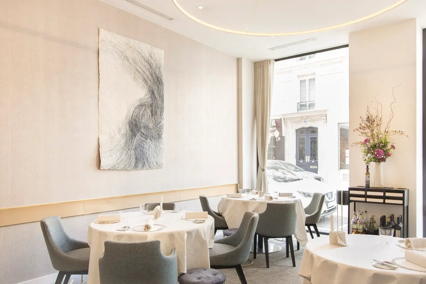 Elegant dining room interior at Alliance restaurant in Paris, featuring modern art and table setting.