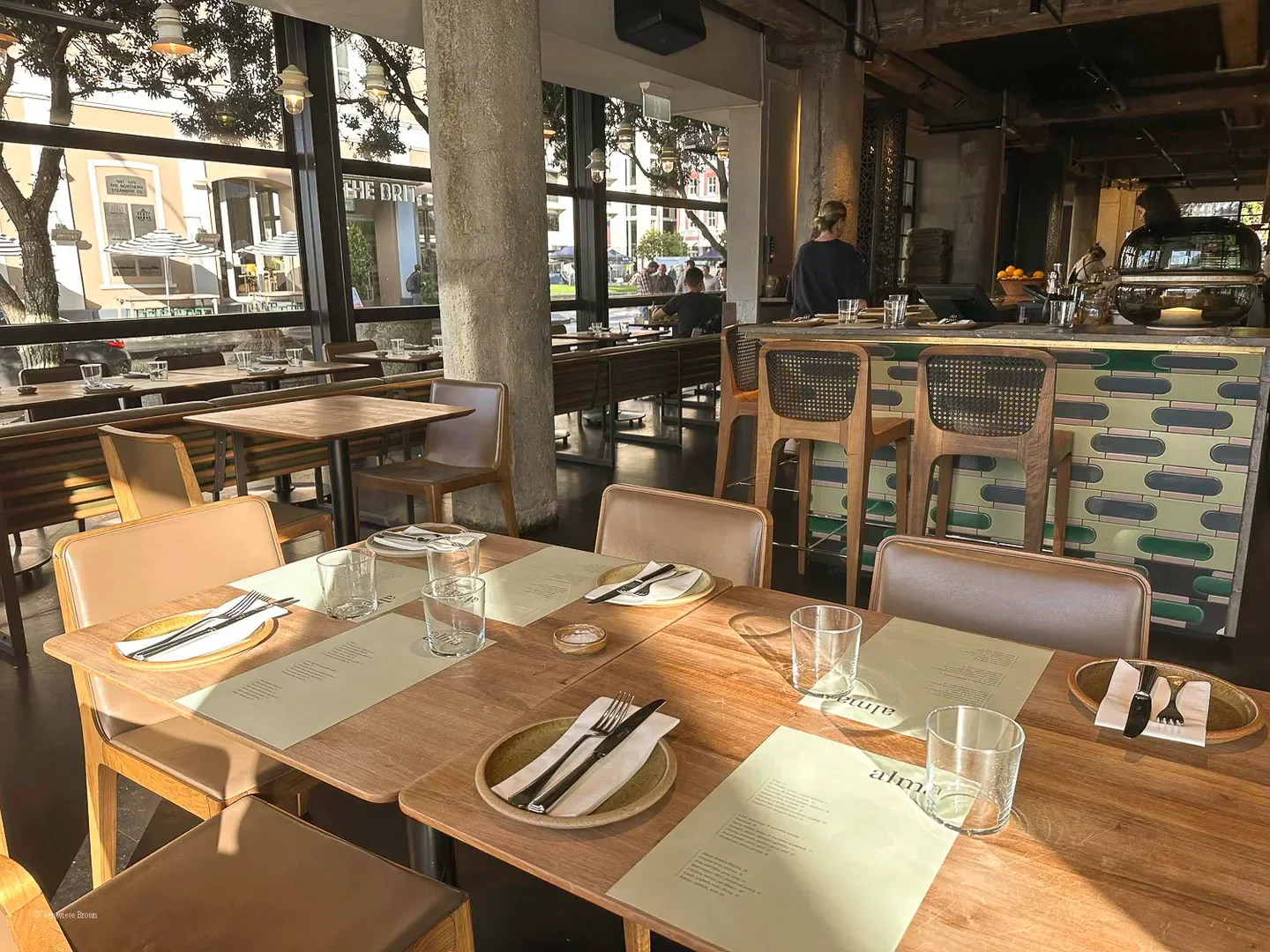 Interior of Alma restaurant in Auckland with set tables and bar seating.