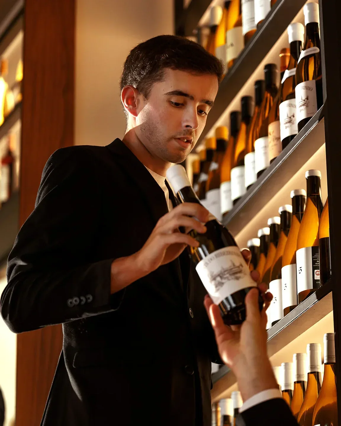 Sommelier at Alma restaurant in Lisbon presenting a bottle of wine from the cellar.