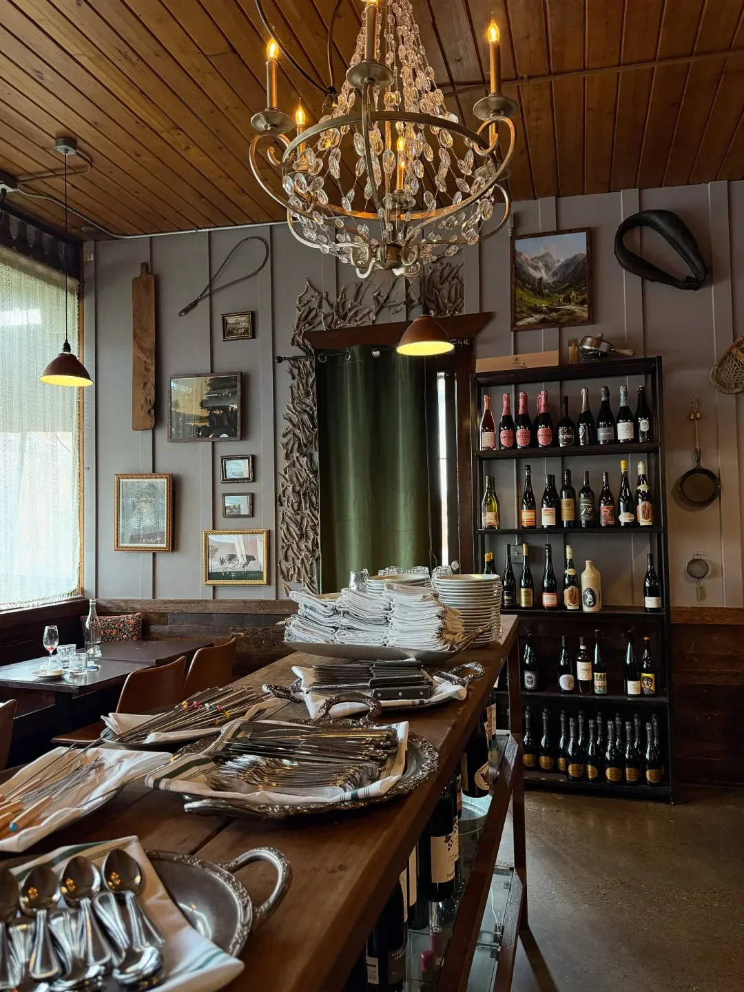 Interior of Alpenrausch restaurant in Portland, featuring silverware and a sparkling chandelier.