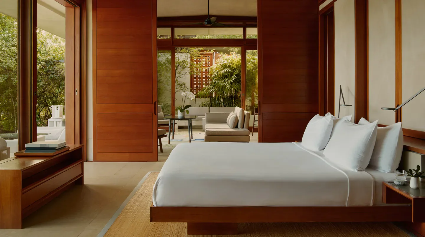 Elegant bedroom at Amanera Macau with wooden doors opening to a tranquil outdoor space.