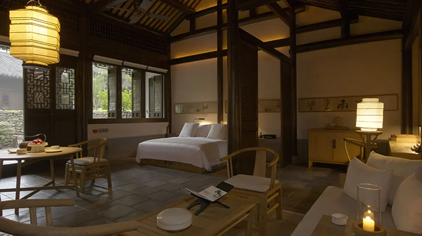 Cozy bedroom interior at Amanfayun hotel in Hangzhou, featuring traditional Chinese decor.