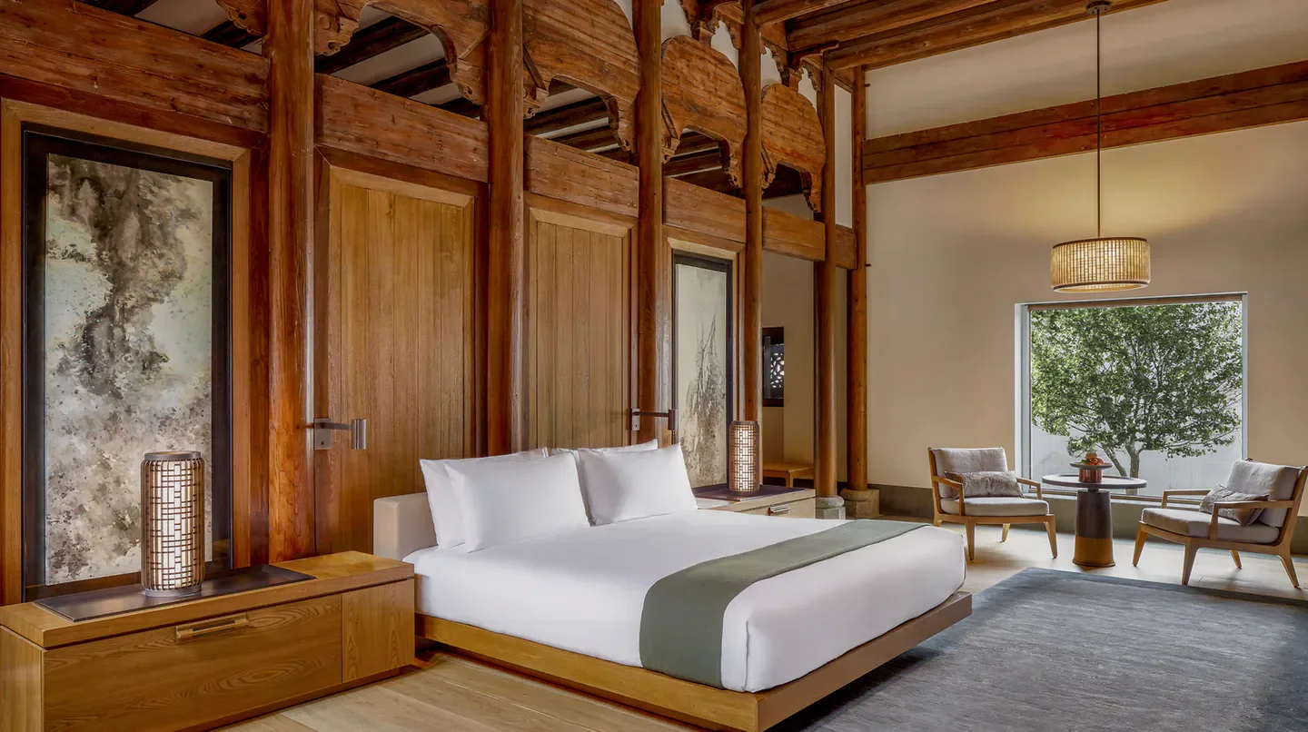 Elegant bedroom at Amanyangyun in Shanghai, featuring traditional wood architecture.