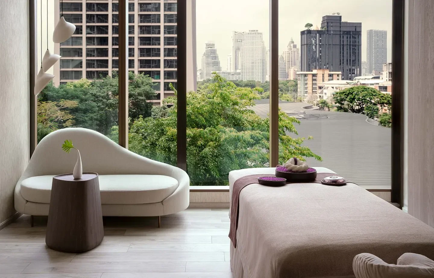 Interior of amaranth spa in Bangkok with a massage bed, sofa, and city views