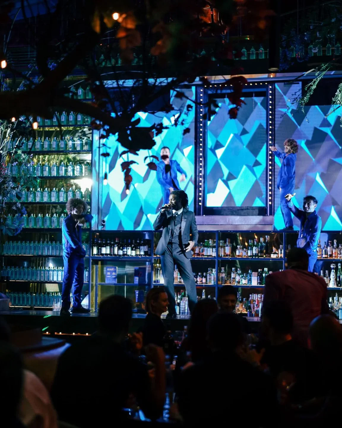 Ambasciatori nightclub in Capri features a live band performing on stage with a vibrant blue geometric backdrop.