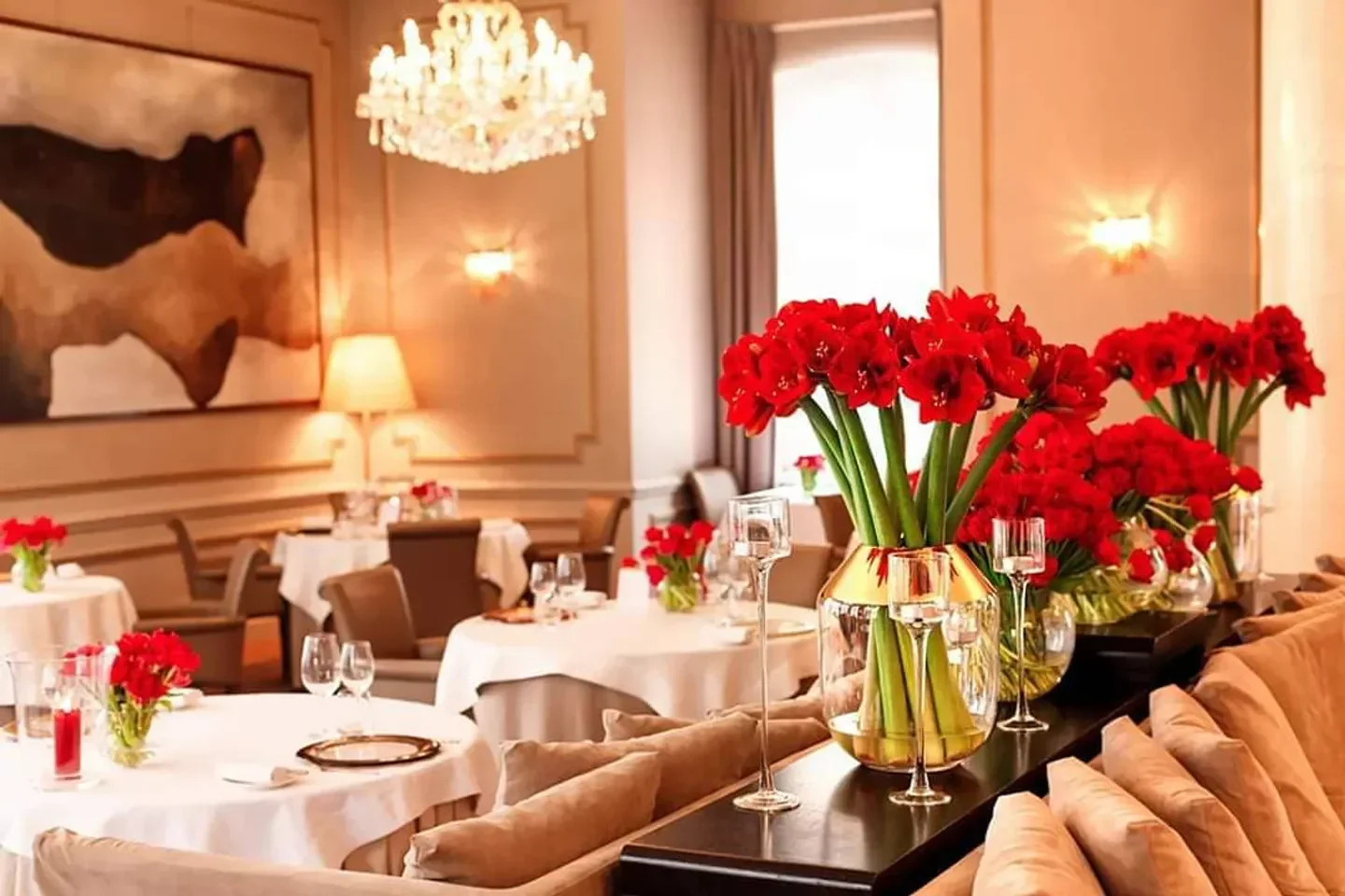 Elegant interior of Amber Room restaurant in Warsaw, featuring red flowers and a chandelier.
