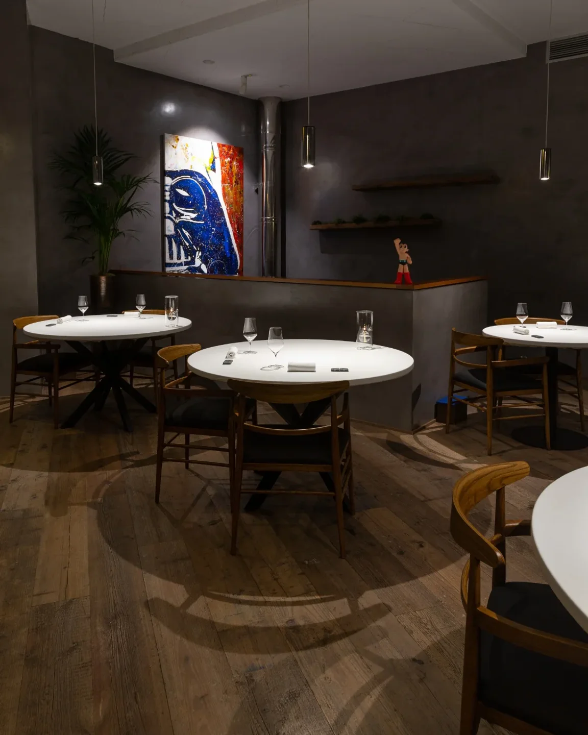 Amelia by Paulo Airaudo restaurant interior in San Sebastian featuring abstract art and modern dining tables.