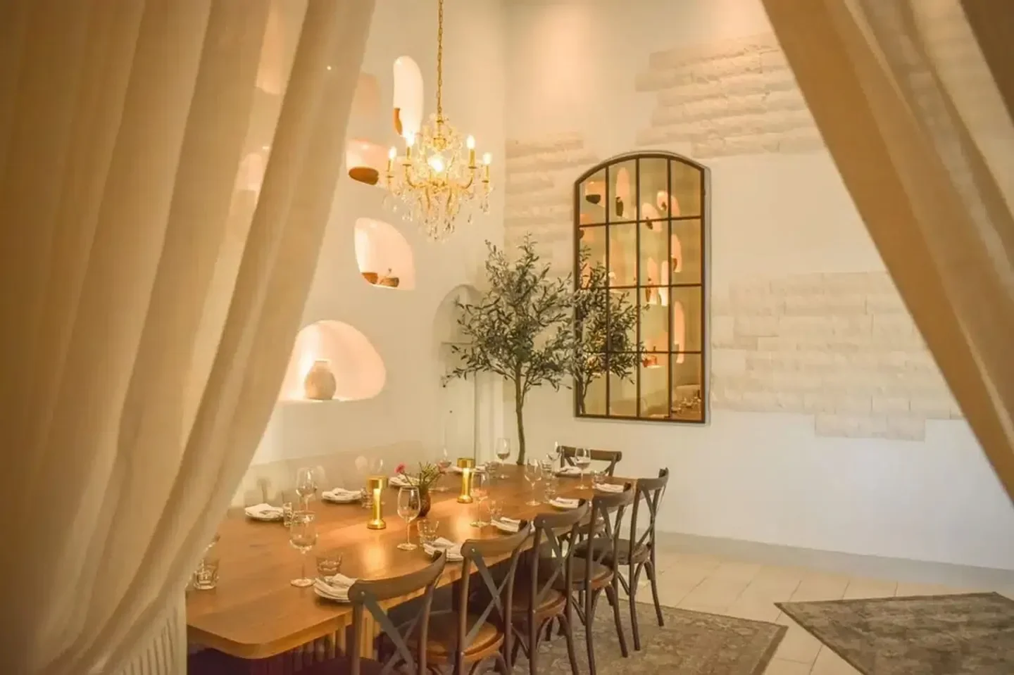 Elegant dining room at Ammatoli restaurant in Orange County, featuring a chandelier and long table.