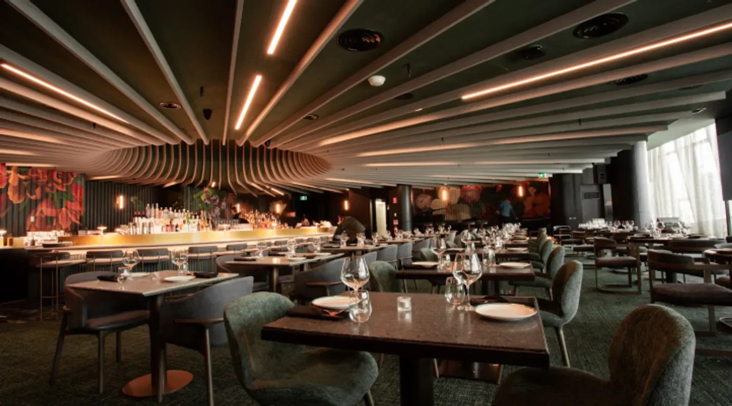 Interior of Anchovy restaurant in Melbourne, featuring tables, bar, and decorative ceiling.