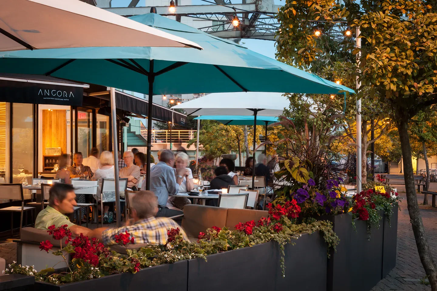 Outdoor patio dining at Ancora Waterfront Dining and Patio in Vancouver, with flowers and guests