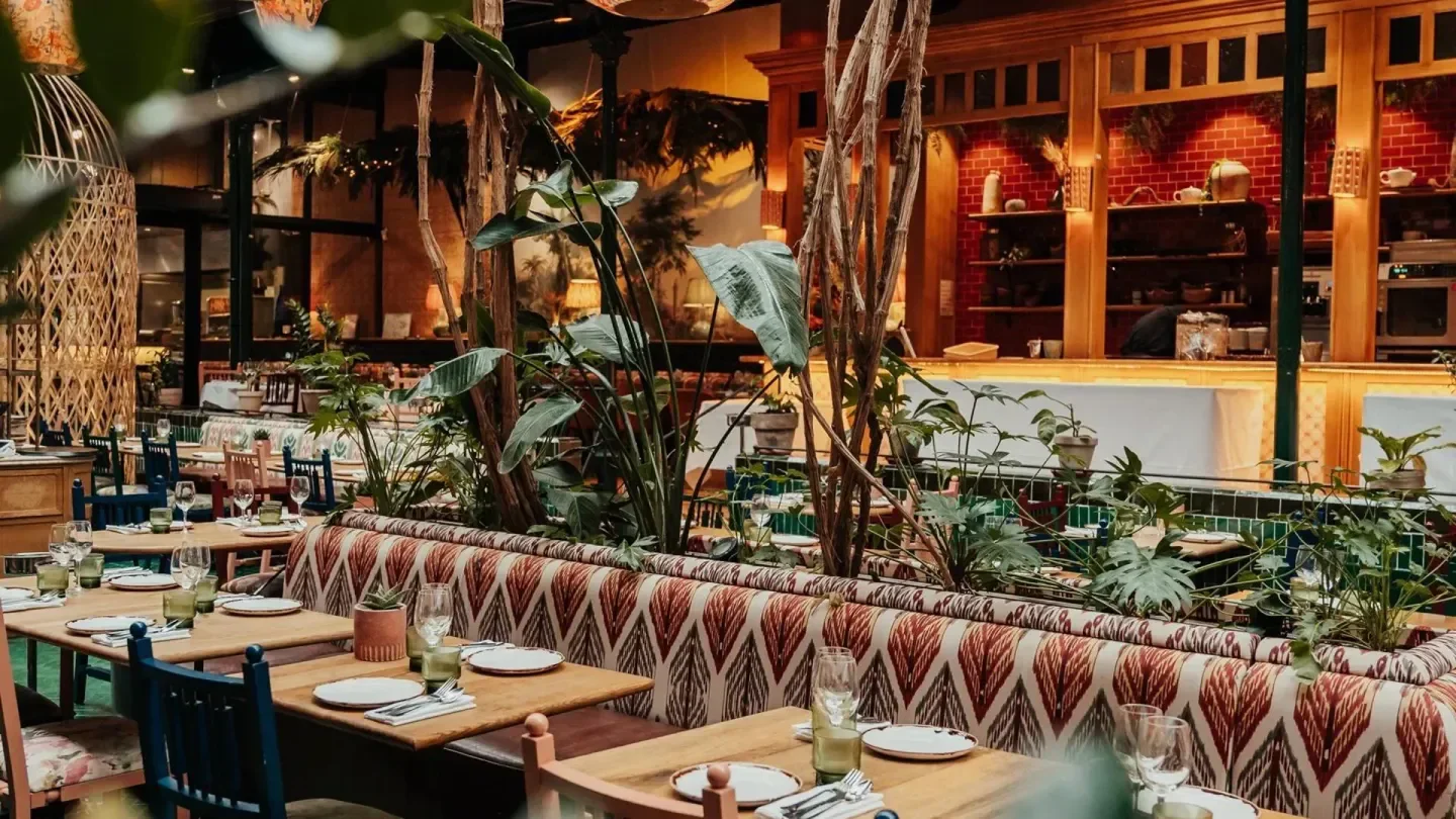 Interior of Andia restaurant in Paris, featuring stylish decor and lush greenery.