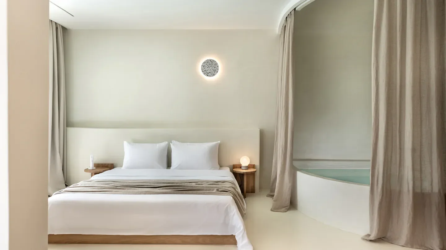 Minimalist bedroom at Andronis Luxury Suites in Oia, featuring a private jacuzzi.