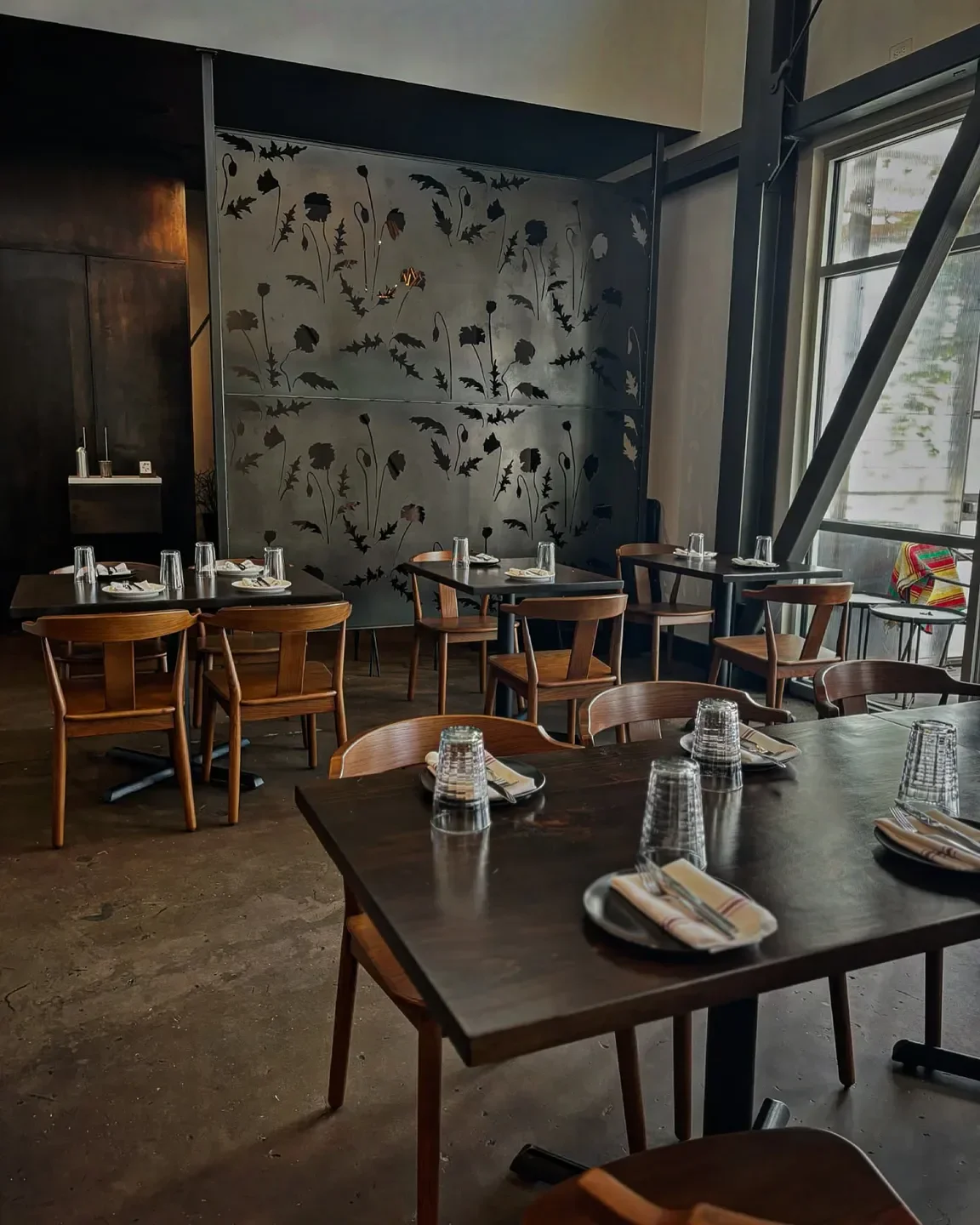 Interior of Annette in Denver with tables set for dining and floral wall art