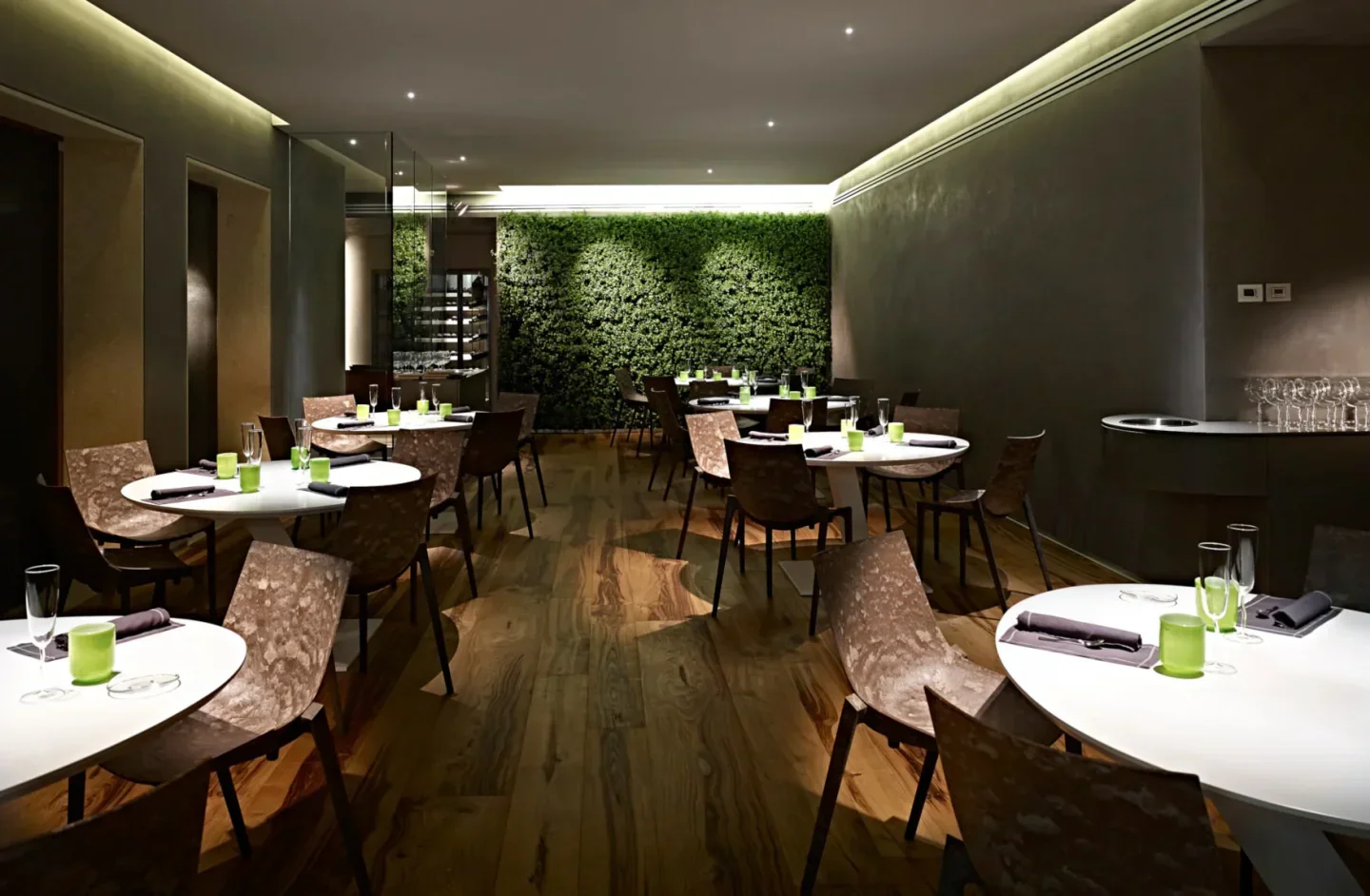 Interior of Aqua Crua restaurant in Veneto, showcasing stylish decor and a unique green wall.