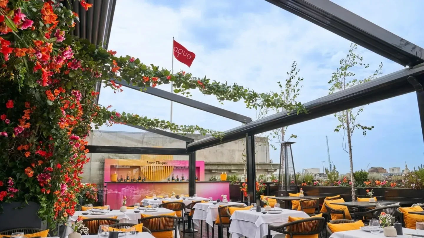 Rooftop dining at Aqua Kyoto in London, featuring floral decor and city views.