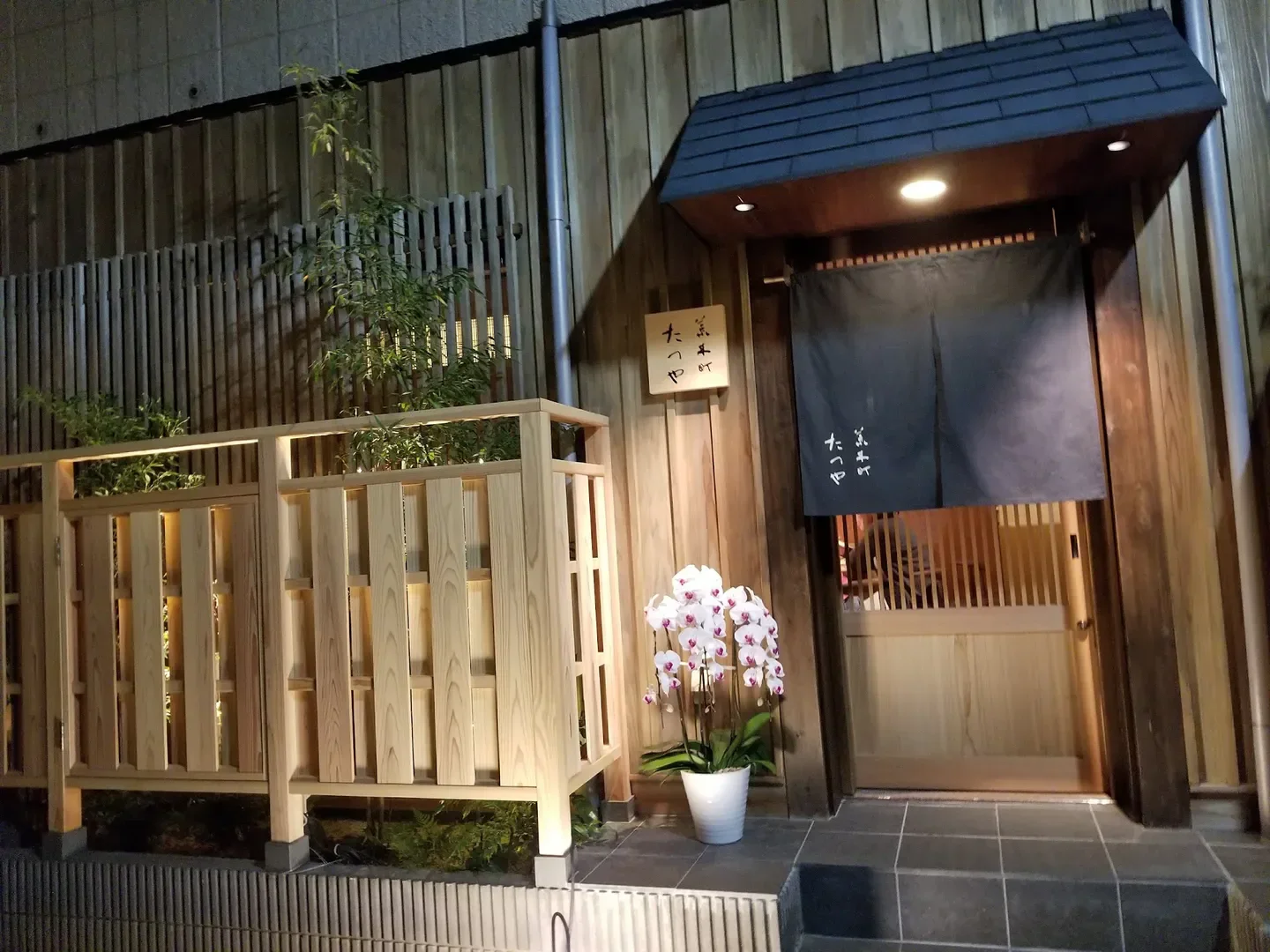 Entrance of Arakicho Tatsuya restaurant in Tokyo, featuring traditional Japanese design at night.
