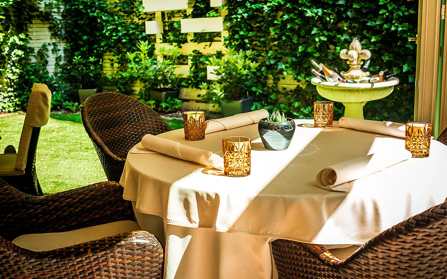 Outdoor dining at Arany Kaviár Étterem in Budapest, with elegant table setting and lush garden backdrop
