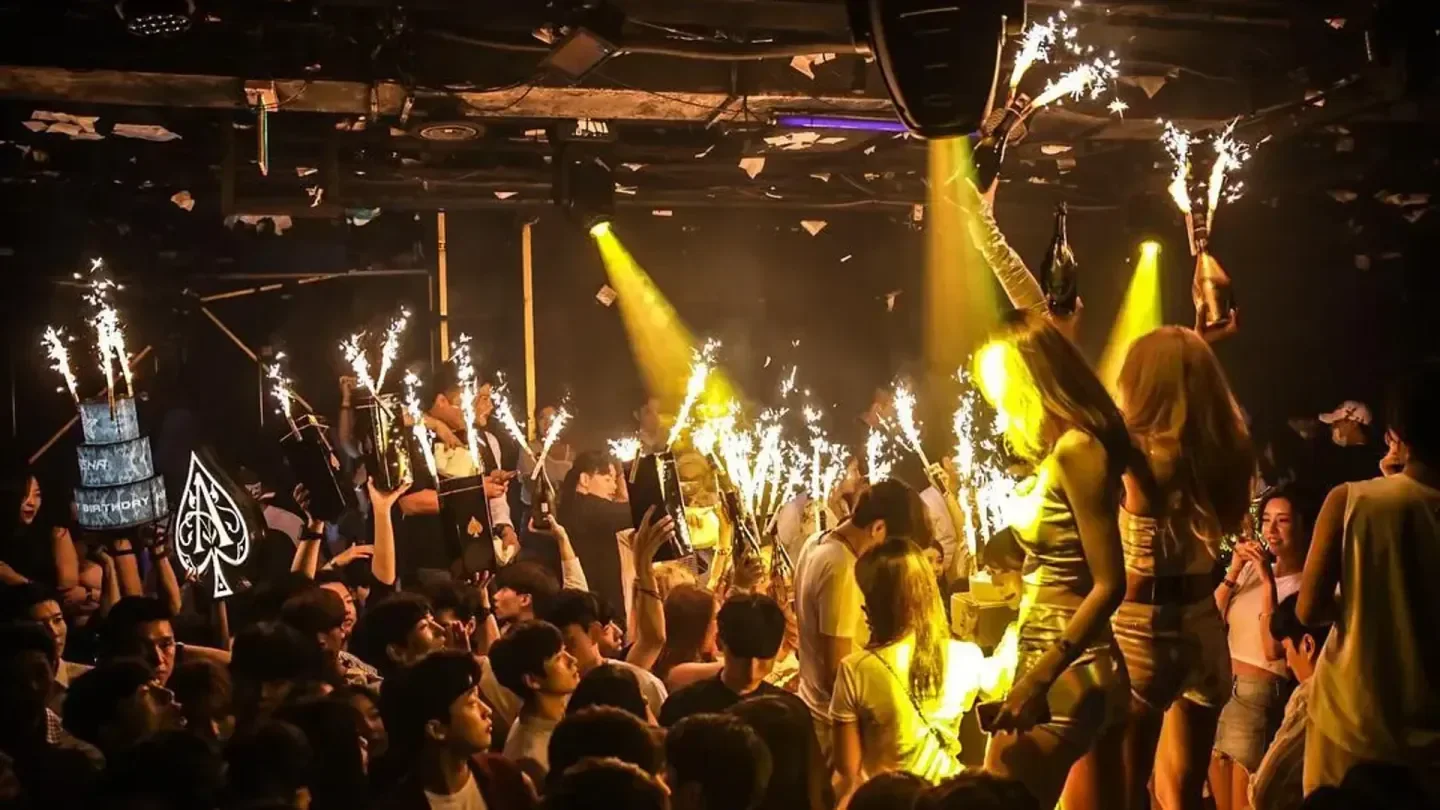Arena Seoul nightclub with crowd celebrating with sparklers and birthday cake