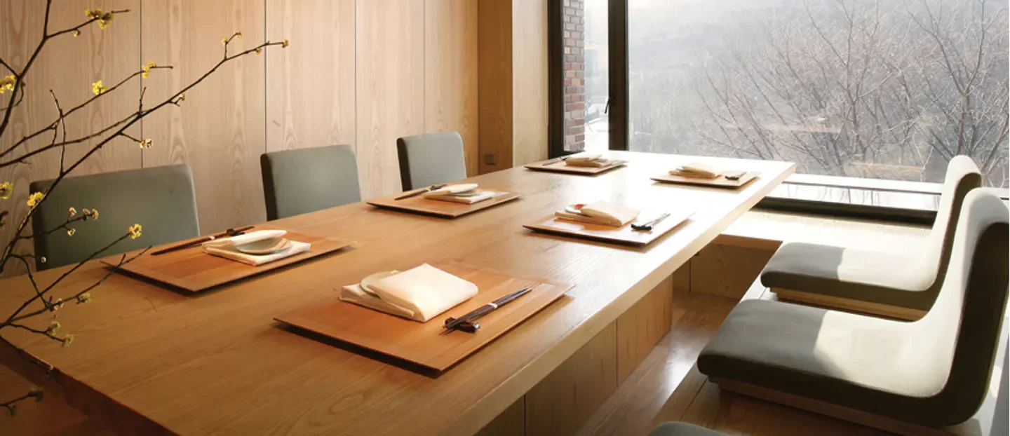 Minimalist dining setup at Ariake restaurant in Seoul, offering serene views.