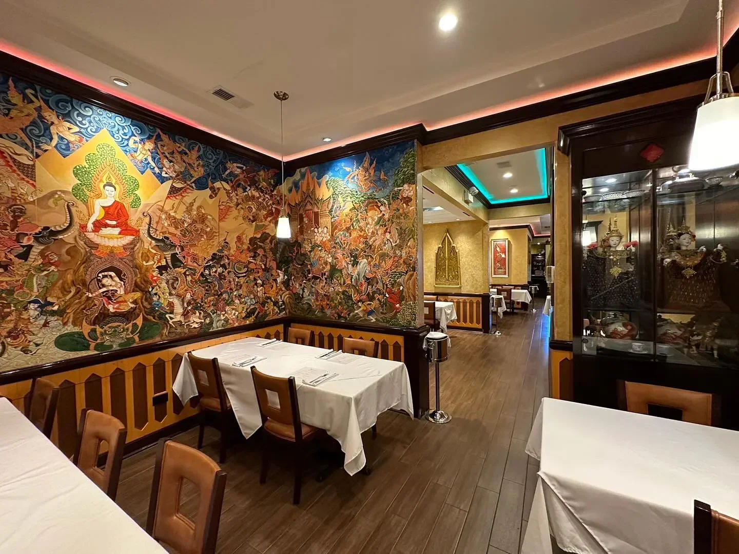 Interior of Arun's Thai Restaurant in Chicago, showcasing colorful mural and dining area.
