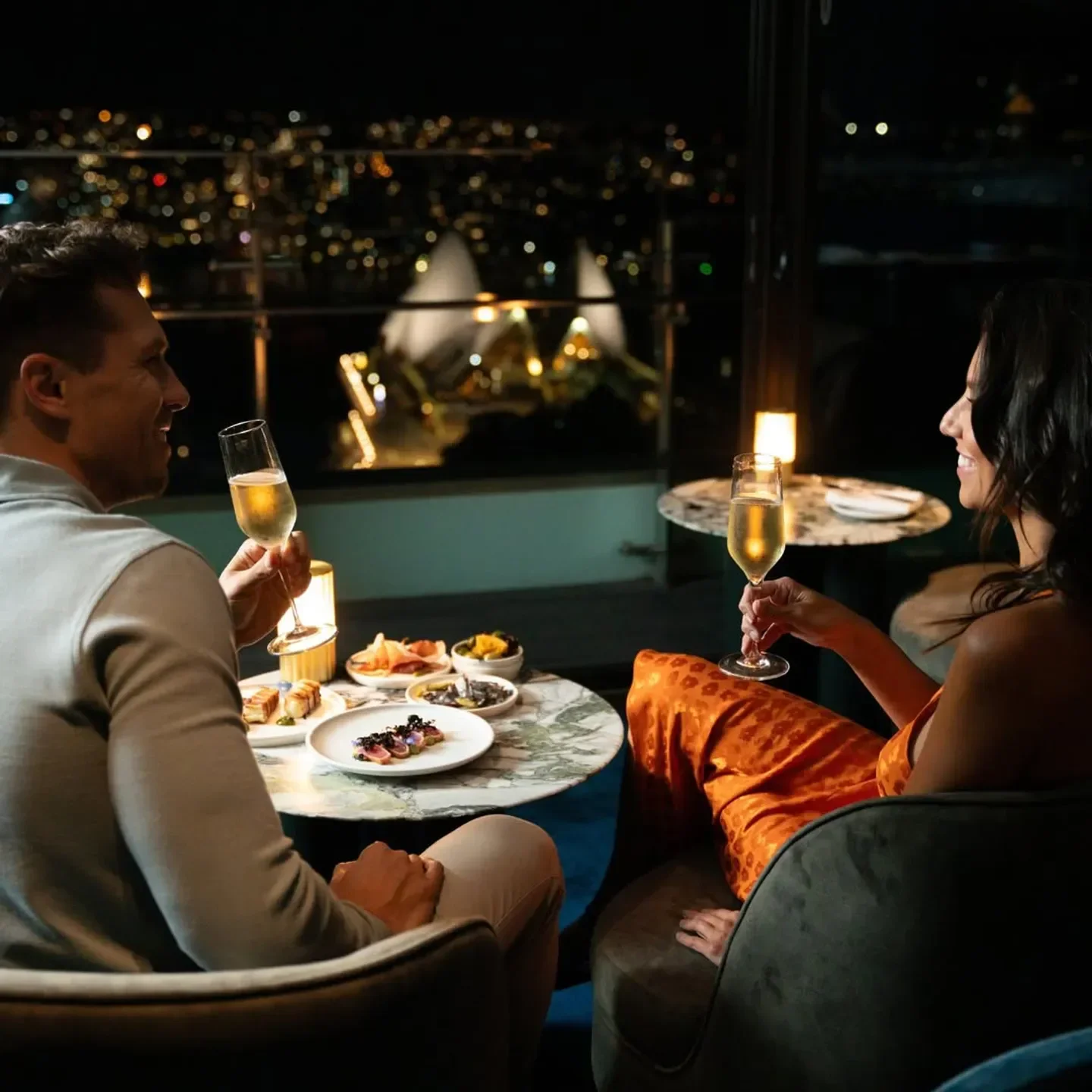 Romantic dinner with views of Sydney's skyline at Aster restaurant, enjoying champagne and food.