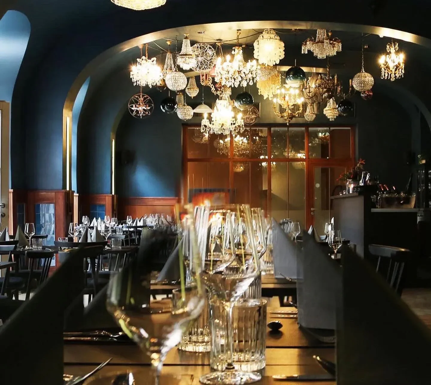 Elegant dining at astrein restaurant in Cologne with sparkling chandeliers and fine glassware.