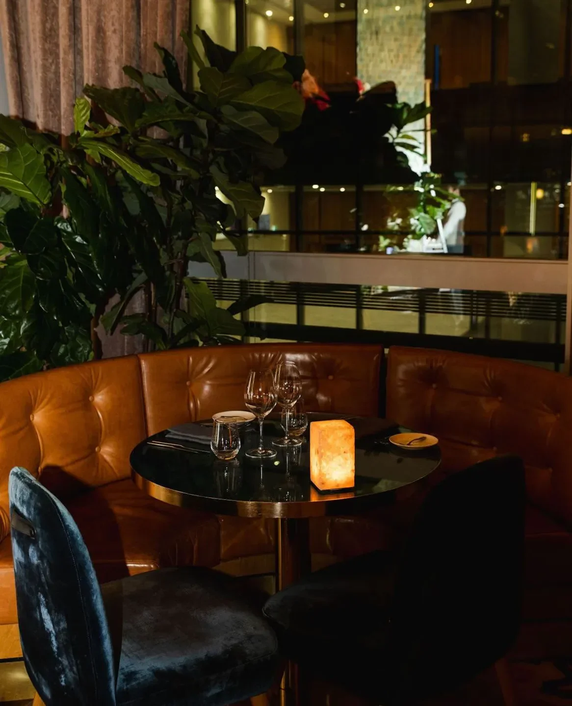 Cozy booth at Atelier restaurant in Sydney, with elegant table setting and ambient lighting.